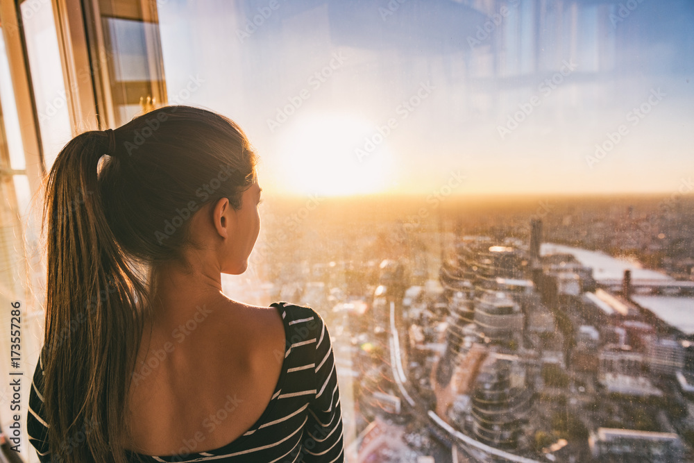 Naklejka premium Europa podróży kobieta patrzeje zmierzchu widok Londyńska miasto linia horyzontu od okno highrise drapacza chmur wierza, sławna atrakcja turystyczna w UK