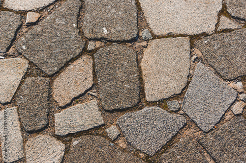 Paving blocks made of asymmetrical granite stone. The stone pavement as the background texture