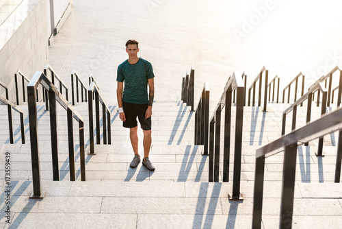 Happy male athlete locating on footway