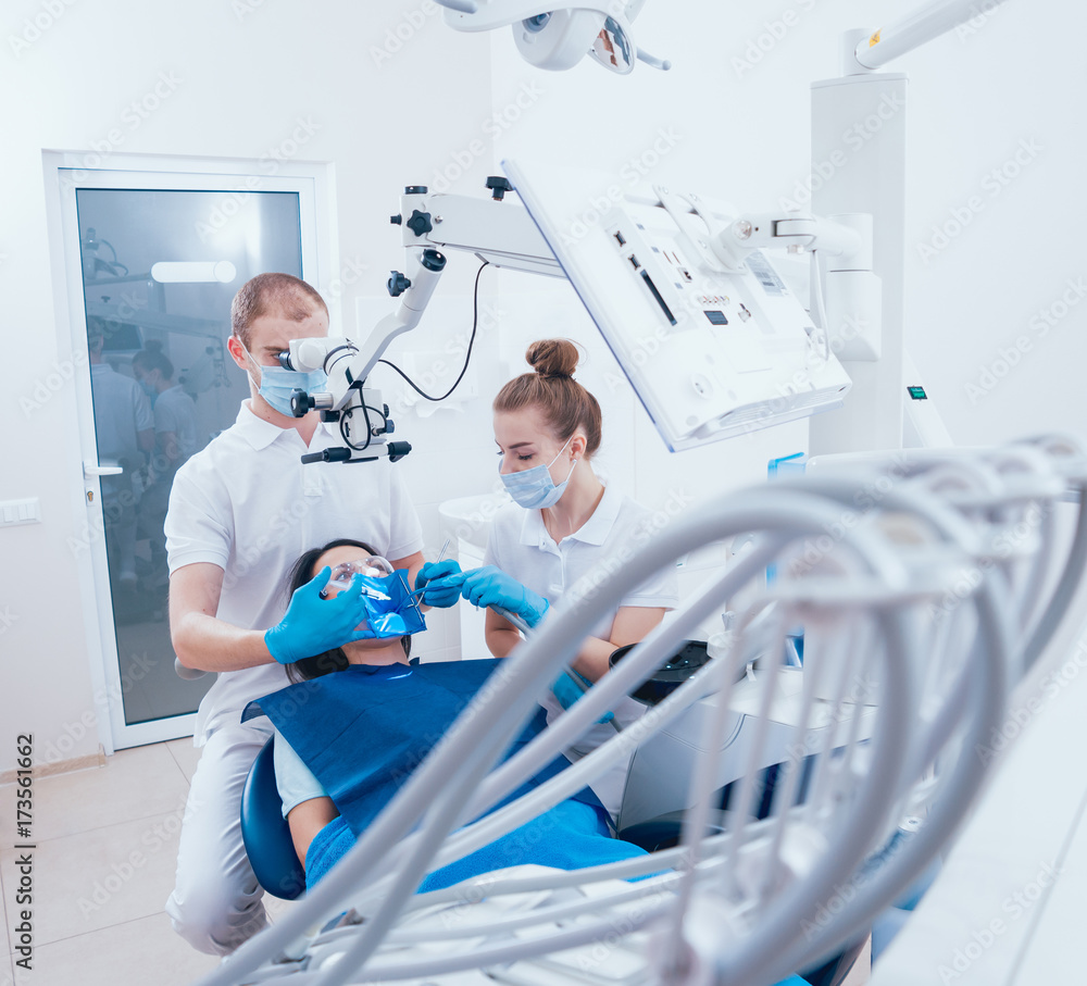 Treatment of root canals under a microscope, work with an assistant