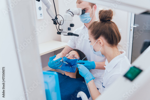 Treatment of root canals under a microscope, work with an assistant.