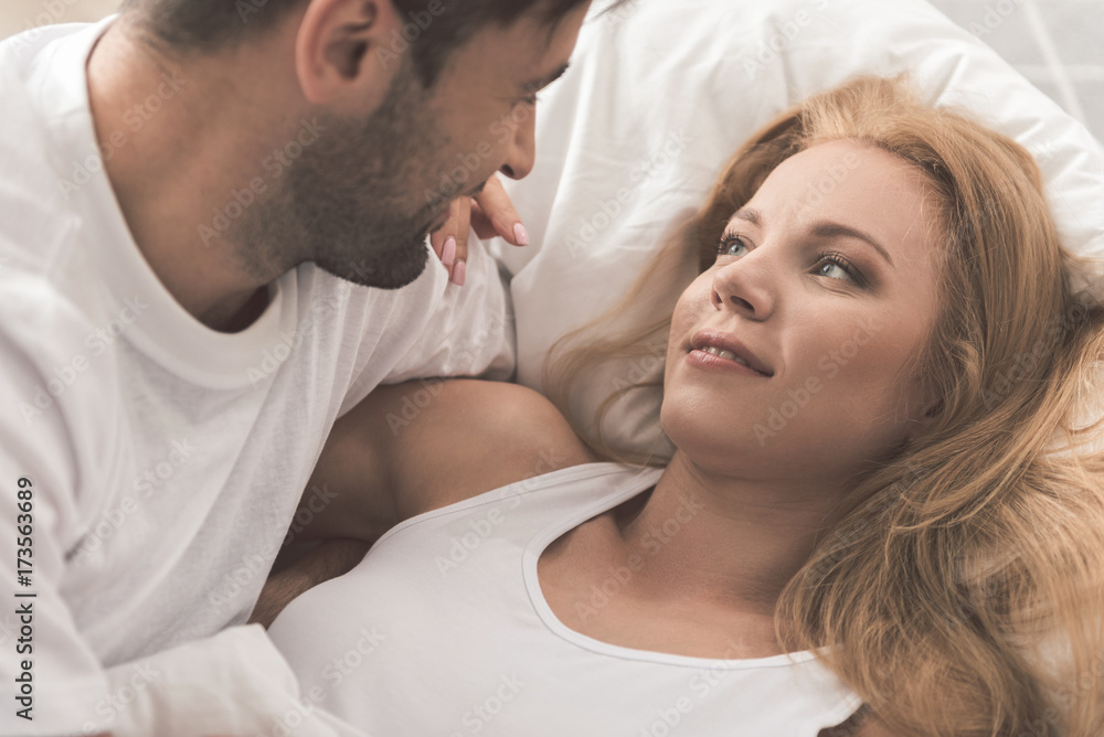 Cheerful man is expressing love to woman in bedroom Cheerful man is expressing love to woman in bedroom