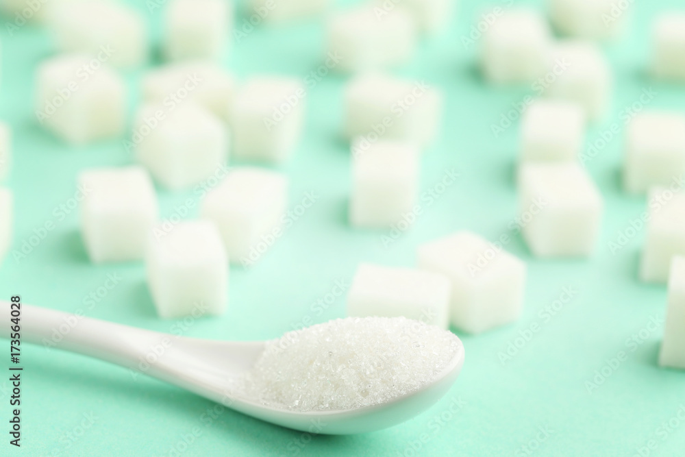 Sugar cubes with white spoon on mint background Sugar cubes with white spoon on mint background