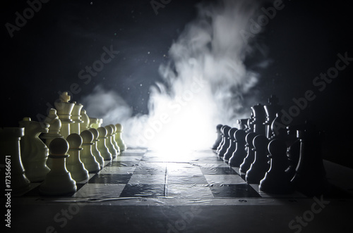 Chess board game concept of business ideas and competition and strategy ideas concep. Chess figures on a dark background with smoke and fog