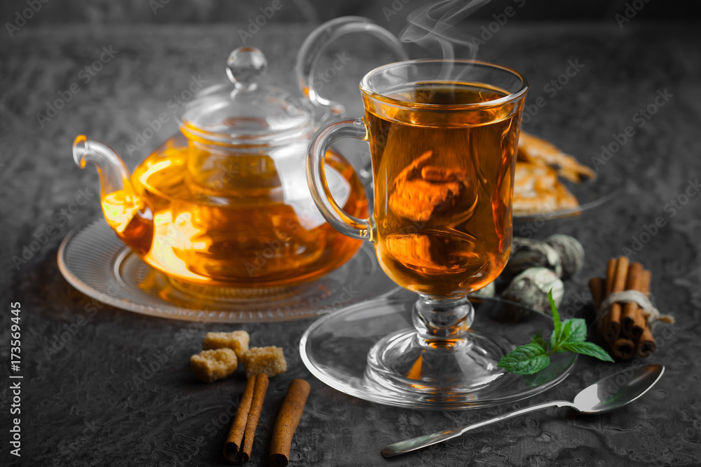 Tea in a cup on a metallic background in a composition with a cookware Tea in a cup on a metallic background in a composition with a cookware