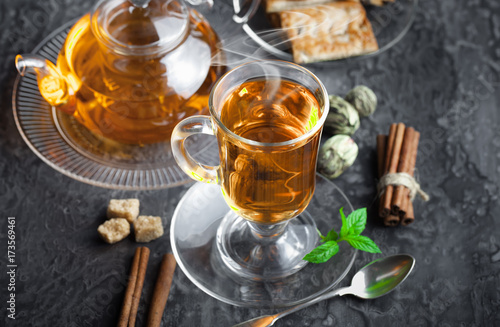 Tea in a cup on a metallic background in a composition with a cookware