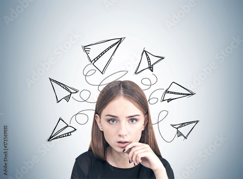 Close up of a pensive teen girl, paper planes photo