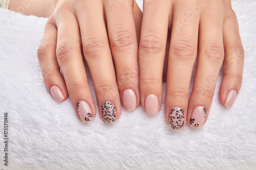 Well-groomed female hands on a white towel. Woman hands with beautiful nail design. Nails care and treatment.