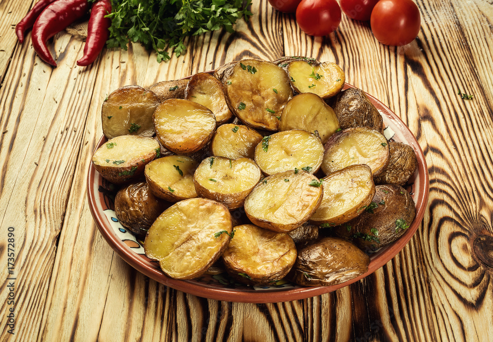 Close up of steaming hot baked potato,Hot buttered jacket baked potatoes,Roasted potato in bowl on wooden table,Oven-baked potatoes with sea salt and rosemary,toasted baked potato strewed with herbs. Close up of steaming hot baked potato,Hot buttered jacket baked potatoes,Roasted potato in bowl on wooden table,Oven-baked potatoes with sea salt and rosemary,toasted baked potato strewed with herbs.