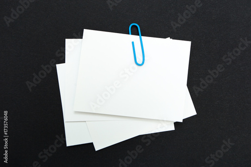 Stack of note paper with blue paperclip. Clipping path included.
