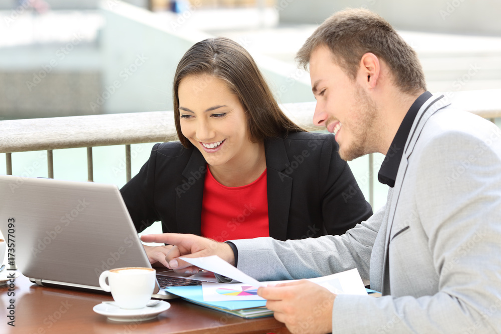 Obraz premium Two executives working on line in a bar