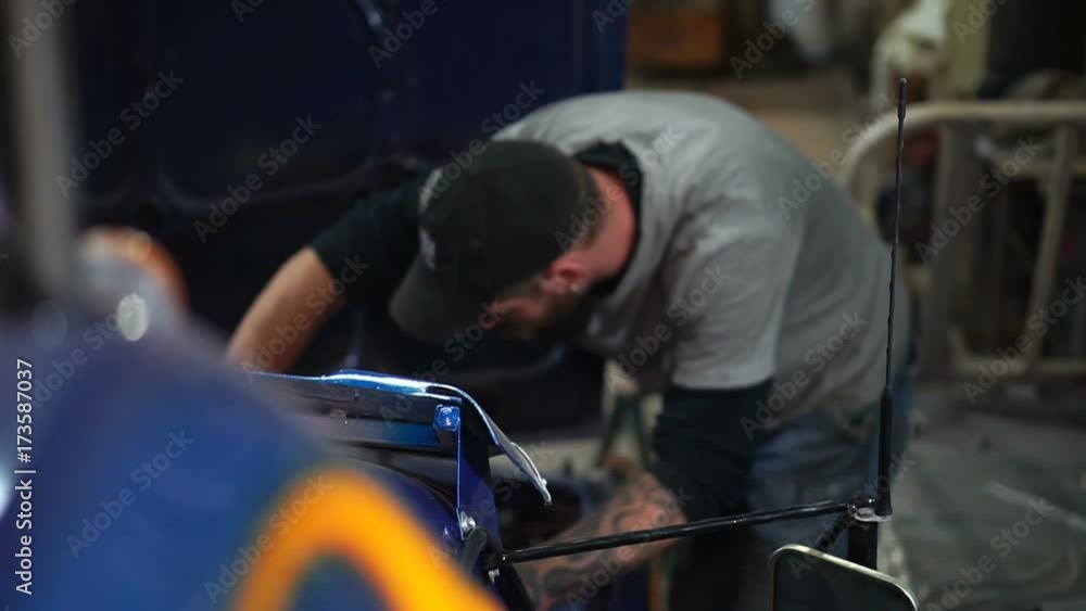 Mechanic in the cap is repairing the car Mechanic in the cap is repairing the car