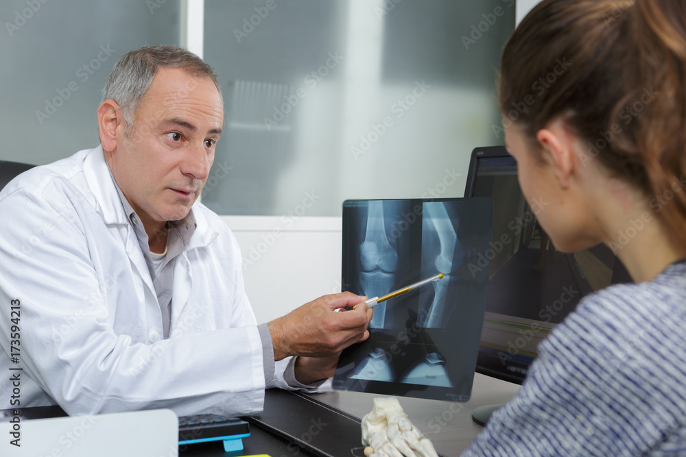 Fototapeta premium doctor showing x rays to his patient in medical office