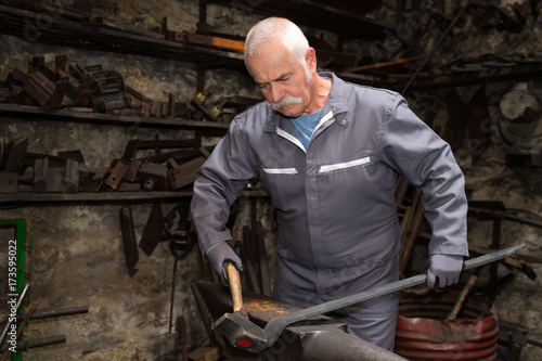 Foto senior tinsmith in his workshop