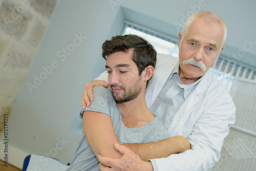 male patient seen from behind with physio therapist