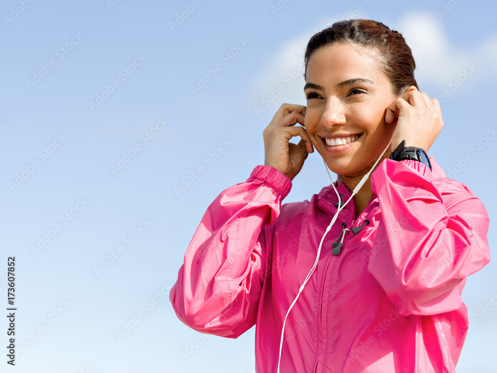 Sporty woman with earphones on the sea coast Sporty woman with earphones on the sea coast