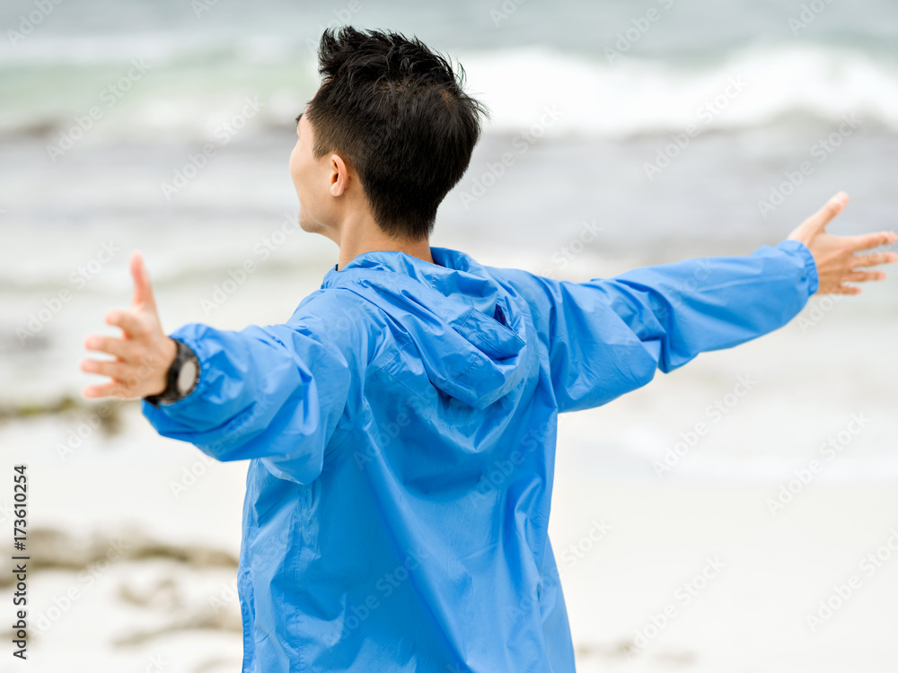 Young man with outstretched arms at the beach Young man with outstretched arms at the beach