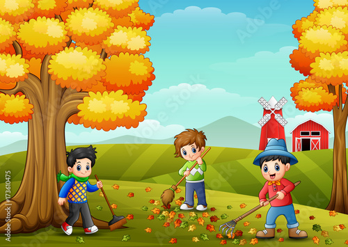 Children raking leaves in the farm yard during fall season