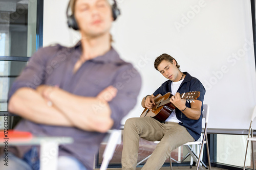 Young man playing the guitar in office