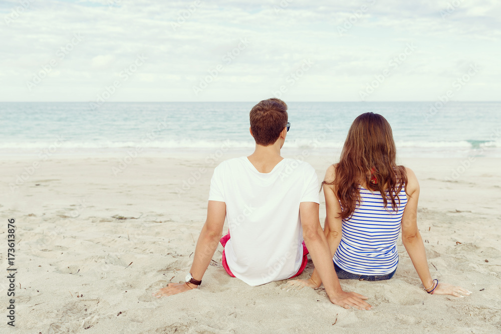 Romantic young couple sitting on the beach Romantic young couple sitting on the beach