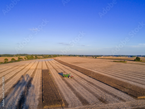 Aerial photo of a tractor in a farm field at sunset during the soybean harvest in Indiana, USA