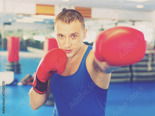 Man boxer is training in gloves in gym. © JackF