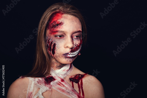Girl with wounds on her face, bloody stains, makeup for halloween, girl