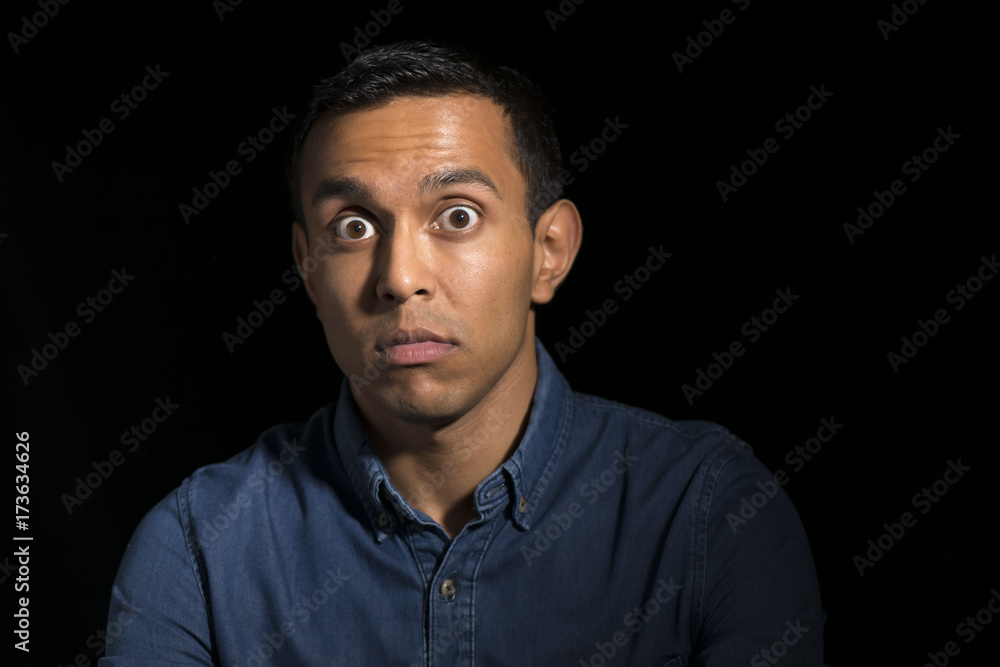 Surprised Man in Denim Shirt Over Black Background Surprised Man in Denim Shirt Over Black Background