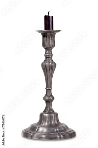 Antique metal candlestick with a black candle