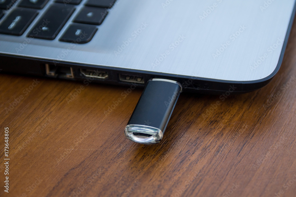 USB memory stick or flash drive attached to the side of a laptop computer USB memory stick or flash drive attached to the side of a laptop computer