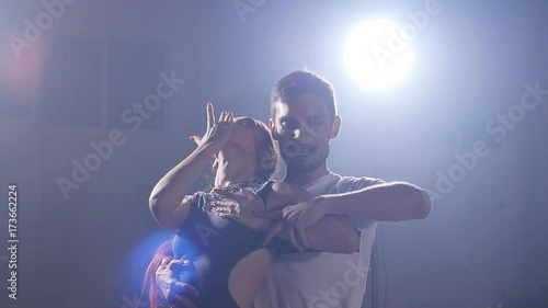 Young couple dancing latin music. Bachata, merengue, salsa. Dark room photo