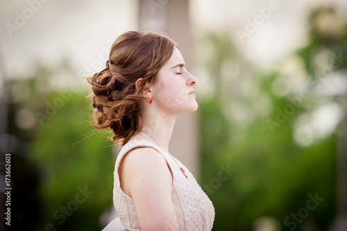Brown-haired girl in elegant light dress in nature. Relax, calmness, reverie.
