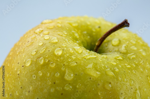 Yellow apple macro covered with water drops