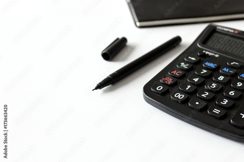 office workplace with text space, black book and calculator on white table with soft-focus and over light in the background office workplace with text space, black book and calculator on white table with soft-focus and over light in the background