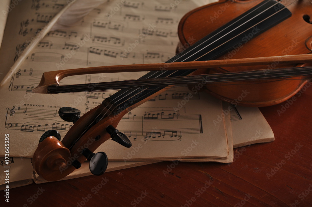 Naklejka premium Violin and notes on the table