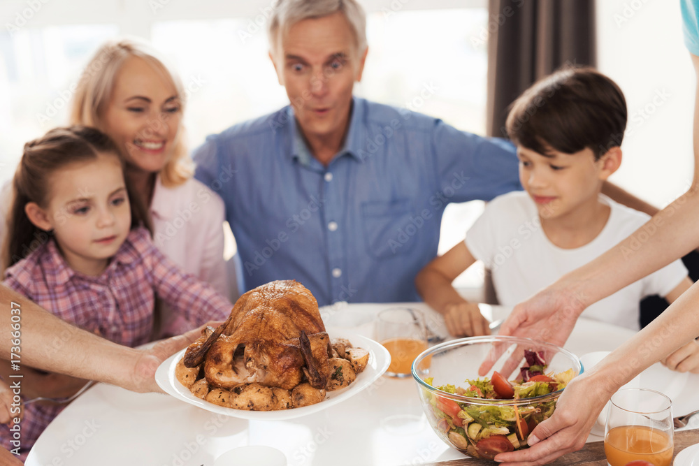 Turkey for Thanksgiving. Family preparing for a festive dinner meeting at the table Turkey for Thanksgiving. Family preparing for a festive dinner meeting at the table