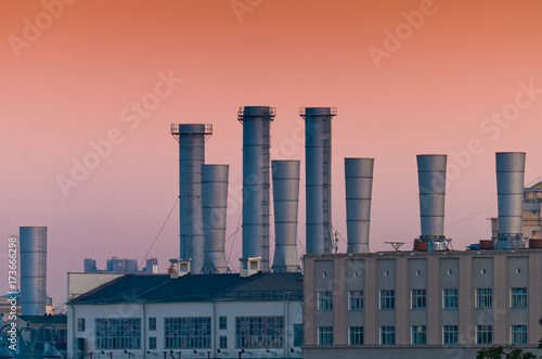 Factory electric company with the red sky. Factory pipes.