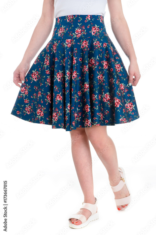 Cheerful woman with sexy long legs and floral skirt over white