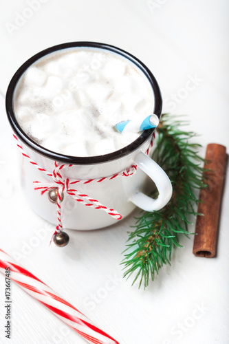 Hot chocolate with marshmallow on white  wooden table. Top view with copy space. Vintage mug of winter cocoa with cinnamon stick. Christmas cozy home concept