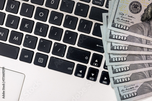 dollar banknotes above white keyboard. close up