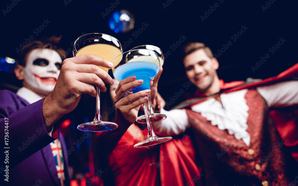© VadimGuzhva - Halloween party. Friends came to the club for a party. No costumes for Halloween. They clink glasses