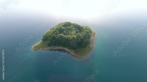 Drone aerial shoot of small island on Ramsko Jezero lake - a tourist destination near Prozor, Bosnia and Herzegovina