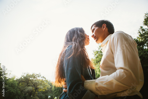 Beautiful young couple on the sunset background