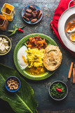 Indian food dish with paneer cheese , curries, rice, naan bread, samosas on dark rustic background, top view
