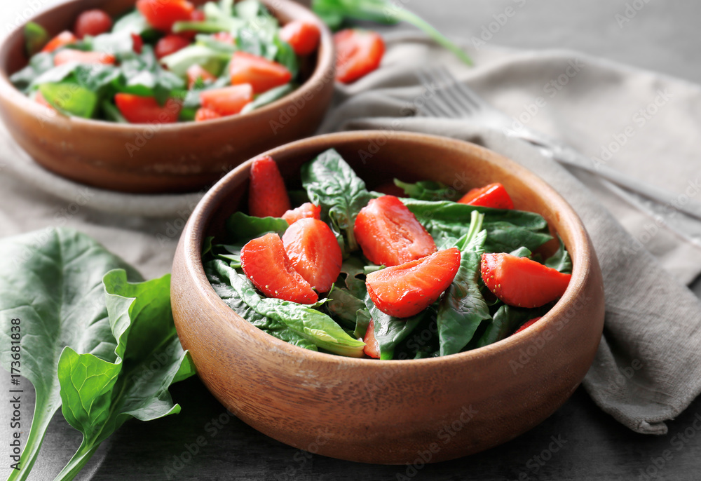 Bowl with strawberry spinach salad on table, closeup Bowl with strawberry spinach salad on table, closeup
