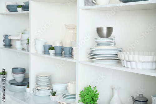 White storage stand with ceramic dishware in kitchen