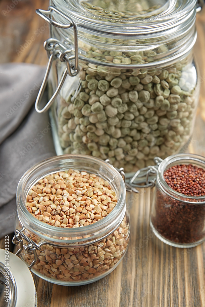 Different grains in glass jars on wooden table Different grains in glass jars on wooden table