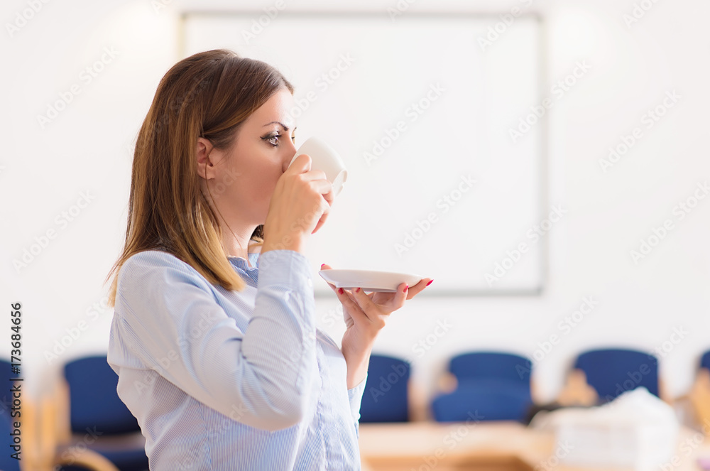 Business woman drinking a coffee before work in the office Business woman drinking a coffee before work in the office