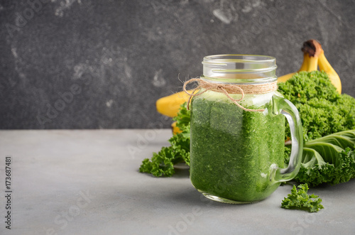 Fresh green smoothie with kale and banana, selective focus, copy space.