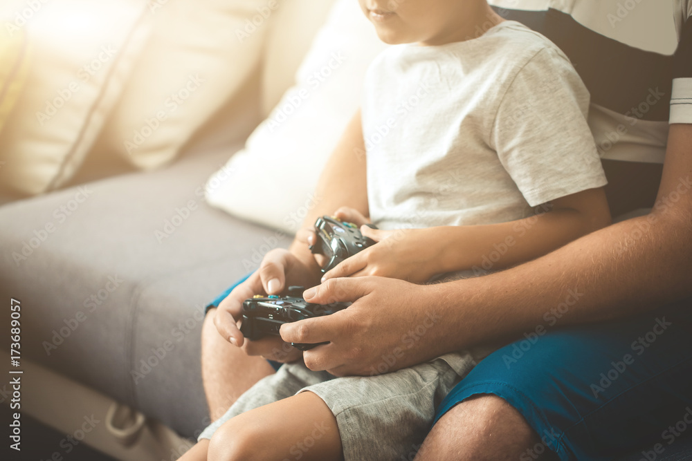Father with son with joystick controllers in hands